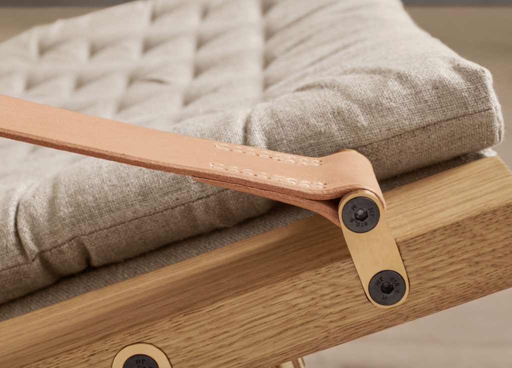 Plico Chair detail of saddle leather armrest, oak frame, and linen cushion