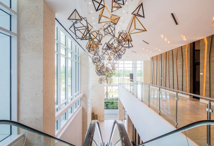 H.E. Williams lighting dramatic triangle shaped chandelier above elevators