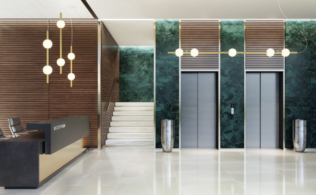Berri Architectural Luminaire gold tubes 3 vertical one horizontal in reception area