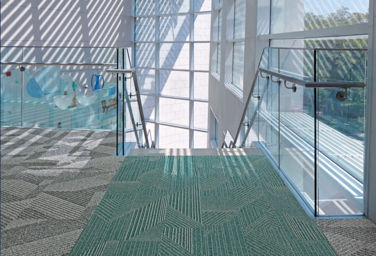 Rising Signs Carpet Tiles Play the Angle gray and blue/green in building mezzanine at top of staircase