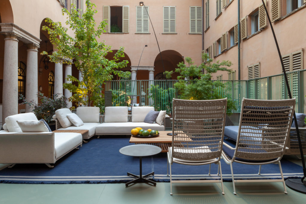 Boundless Living Solaria collection sofa and chairs with Teak table on blue carpet