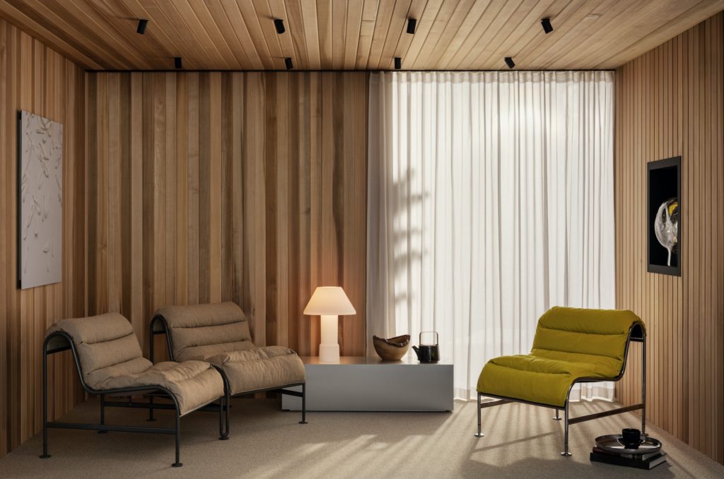 Sunny Chair gray two chairs linked together at slight angle and solo chair in mustard in nice room with beige curtains and wood paneling