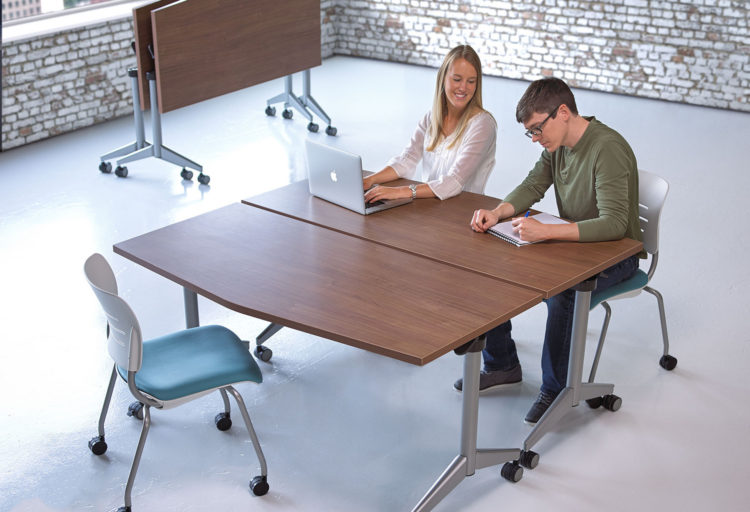 KI Pirouette Table dark wood top with man and woman working side by side in open room
