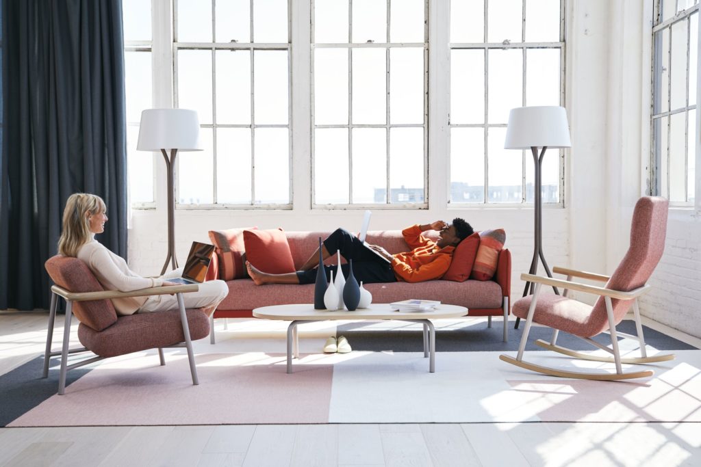 Teknion Routes rocking chair, lounge chiar, and sofa with woman in chair and man on sofa in sunny workspace