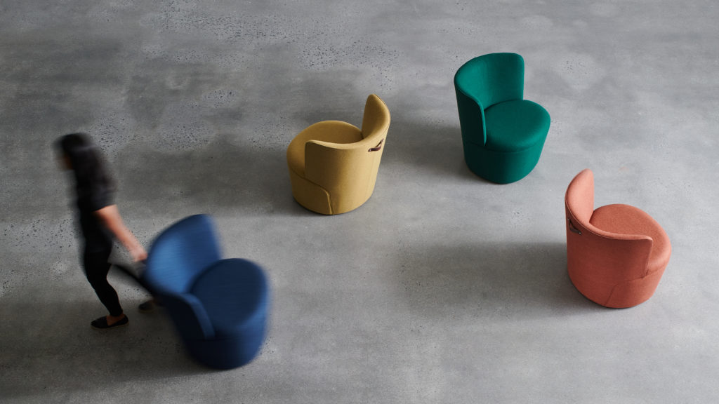 Davis Furniture's Tote overhead view of four chairs in yellow, orange, green, and blue with woman moving the blue chair