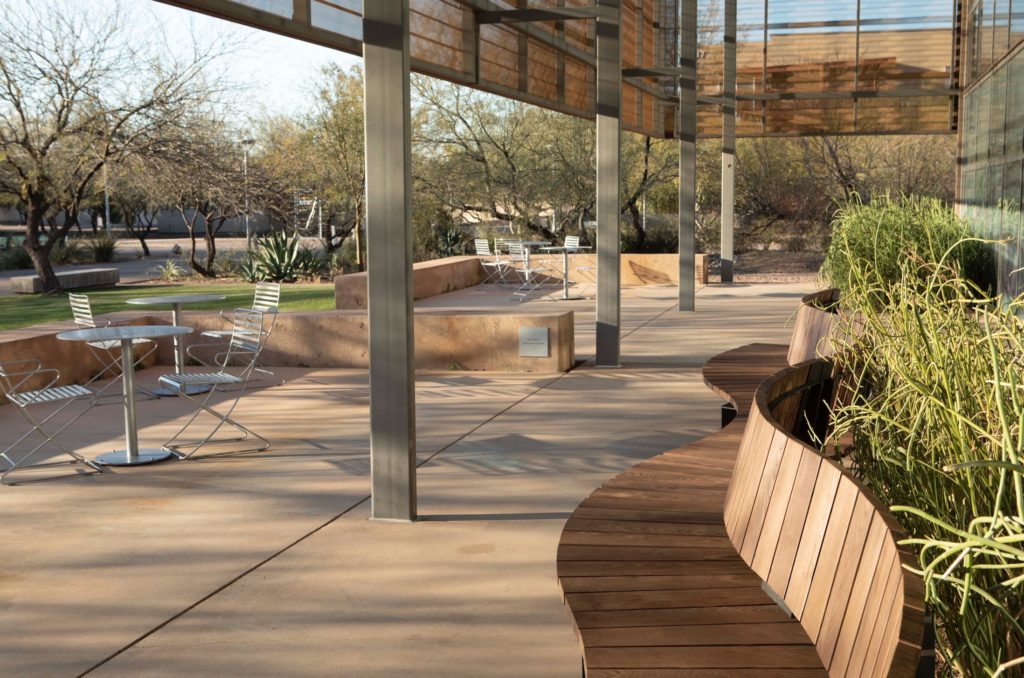 Link Serpentining bench on outdoor patio with shade structure above and café tables