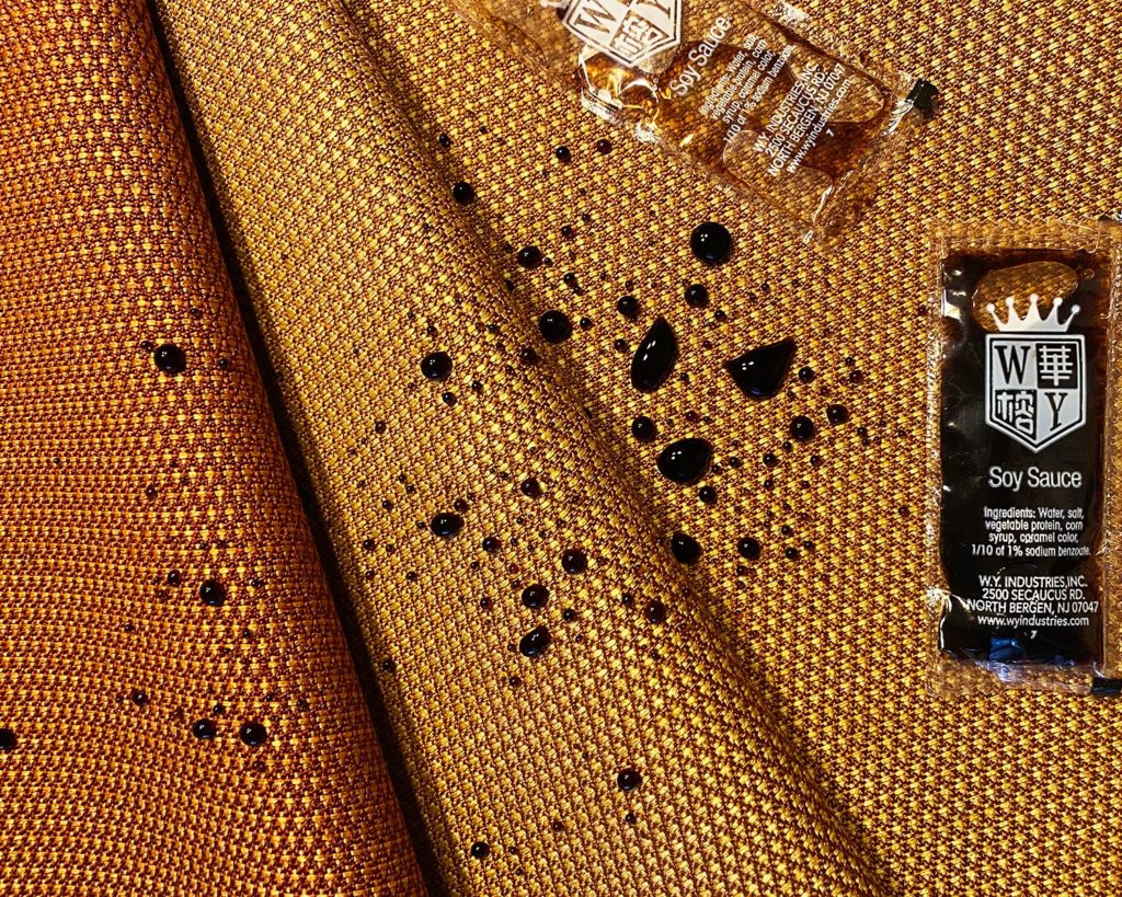 Supreen on gold-colored fabric repelling soy sauce