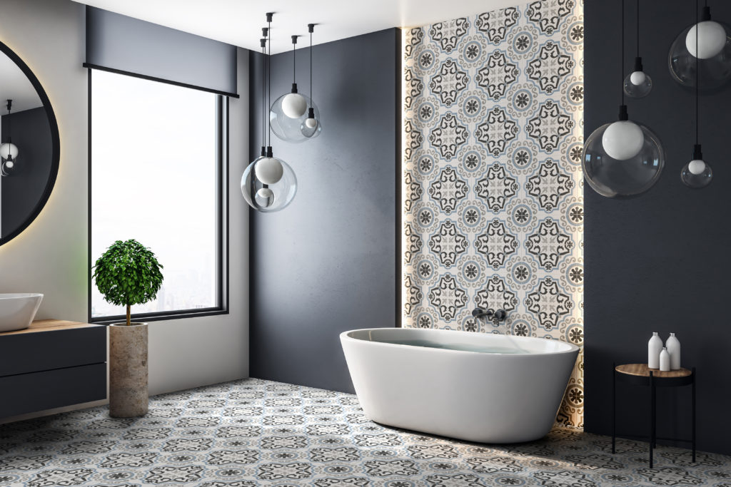 Walker Zanger Studio Cement collection ornate design on wall of bathroom with bathtub in foreground