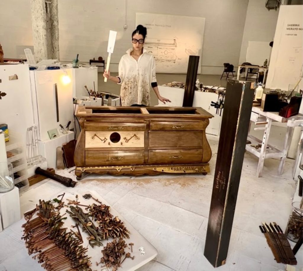 Sabrina Merayo Nuñez the artist working on a chest of drawers