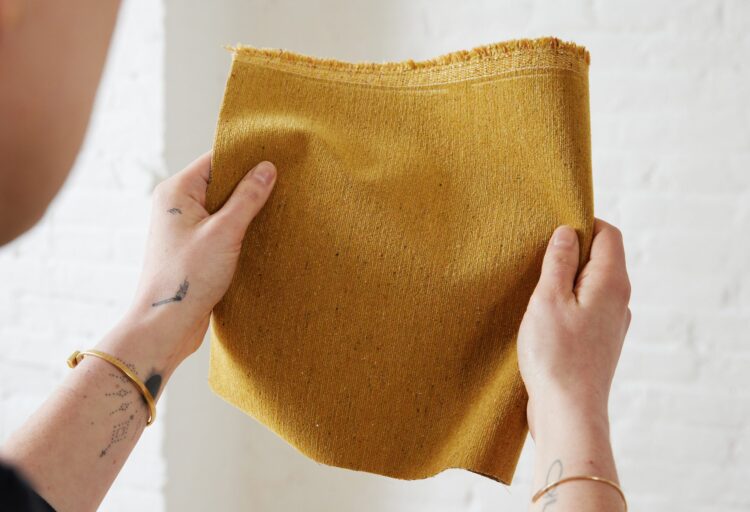 Dusted Fleck gold swatch held in hands