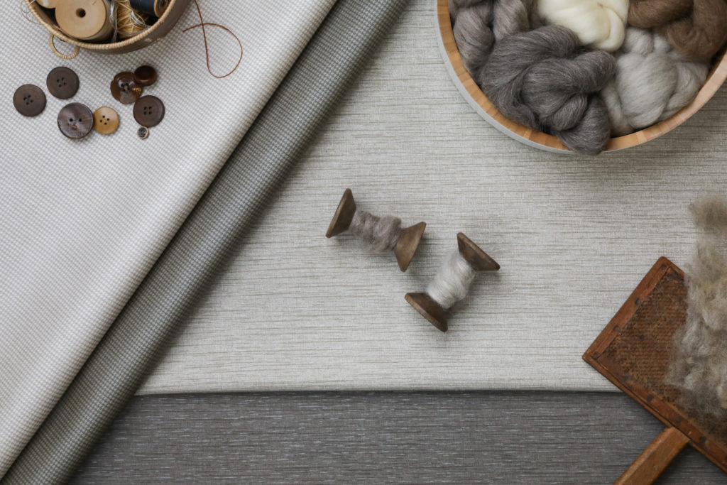 Baxter and Suri Suri in off white and dark gray with Baxter swatches and yarn samples and spools