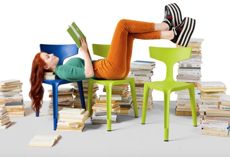 Stakki girl reclining on two chair while reading