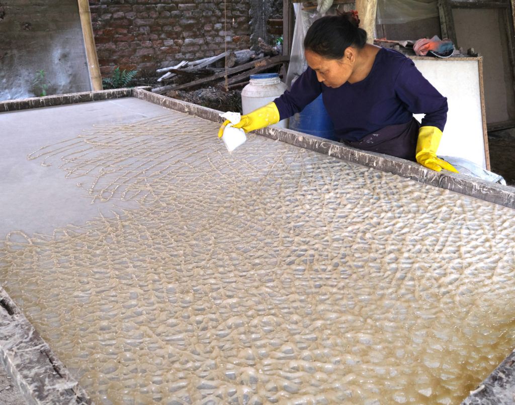Artisan hand-piping Lokta paper