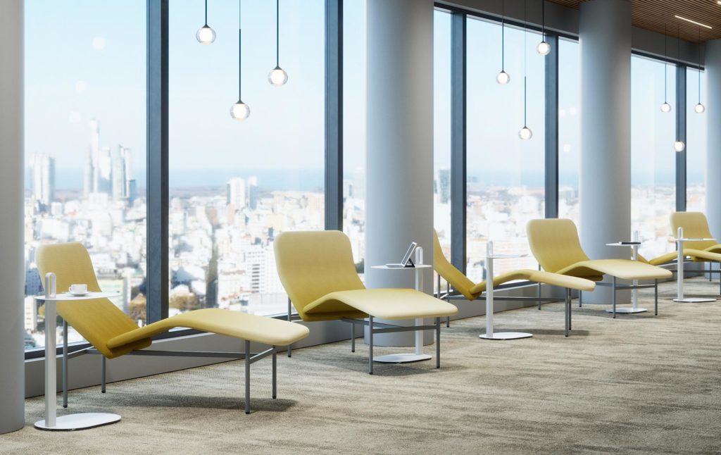 row of lounges in front of large windows in city skyscraper