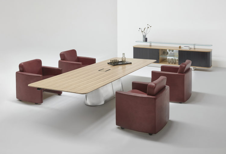 Vox LCS in office setting surrounded by maroon colored lounge chairs