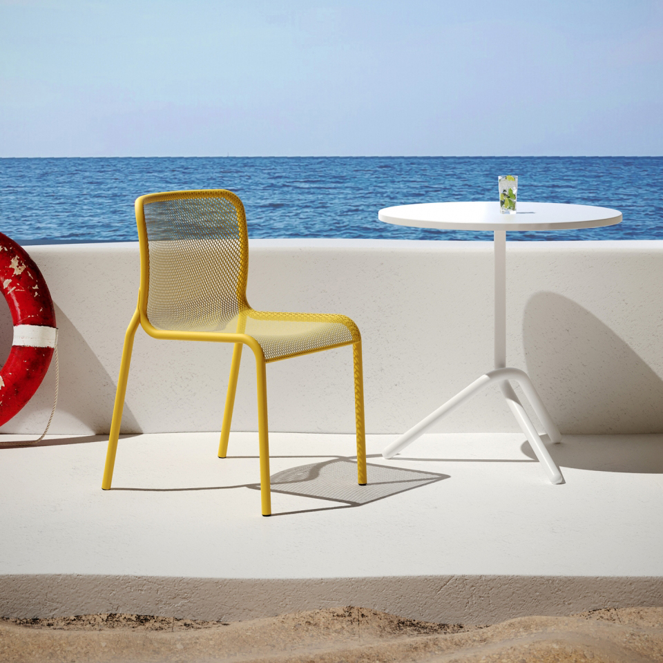 Yellow Momo at small cafe table on a boat with ocean in background
