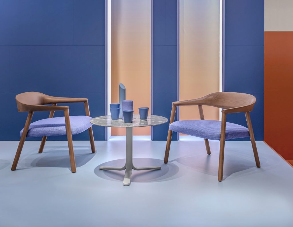 Pair of Héra lounge chairs with lilac upholstery and coffee table with matching mugs in display room