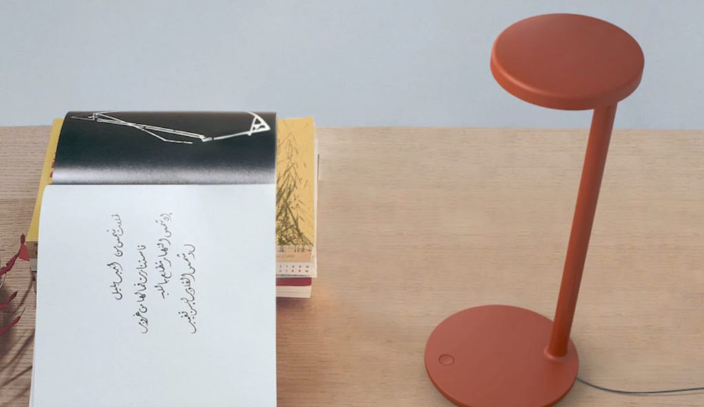 orange Oblique table lamp on table with books