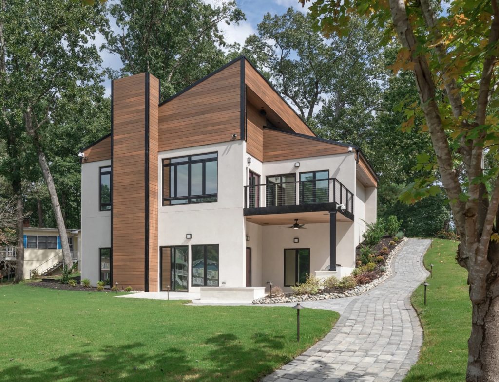 Wildwood cladding on chimney and upper level of nice house surrounded by large trees