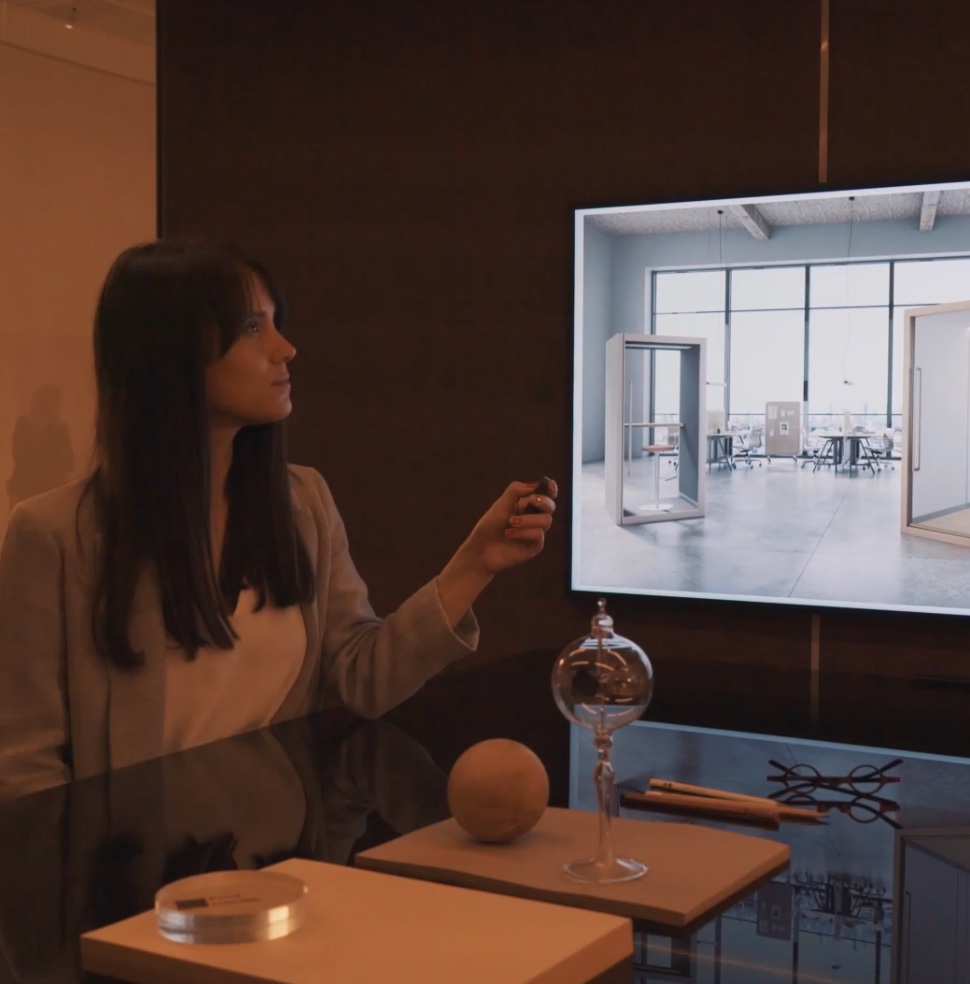 Woman inside pod looking out window at space with other pods