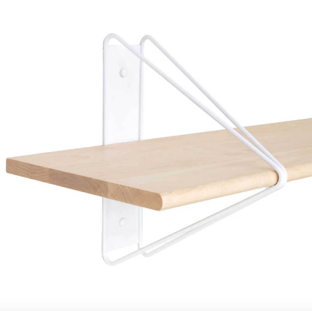 Detail of bookshelf with white wall plate, strut, and wooden shelf