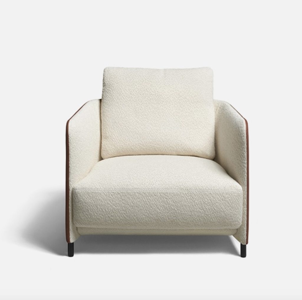 a handsome lounge chair viewed from the front with soft cushy white upholstery