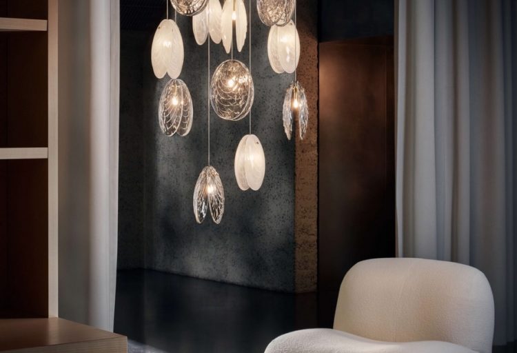 Mussels chandelier above chair in dark room