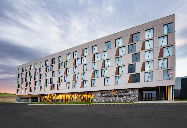 Dakota Dunes hotel at evening with orange sunset reflected in lower level curtain wall