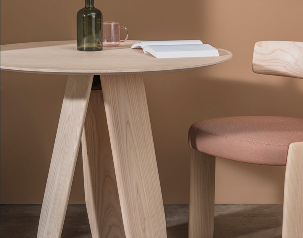 detailed view of a wooden, three-legged table and chair