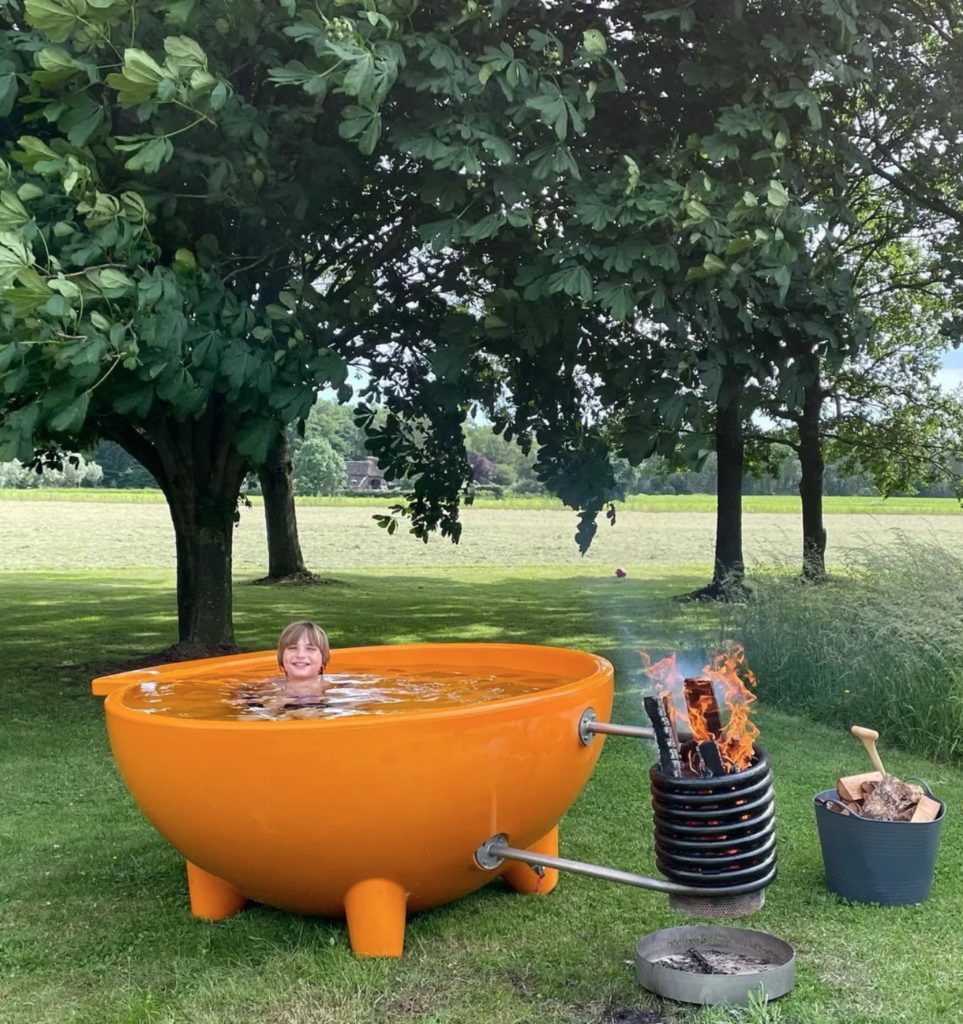 Boy in orange Dutchtub in backyard with trees