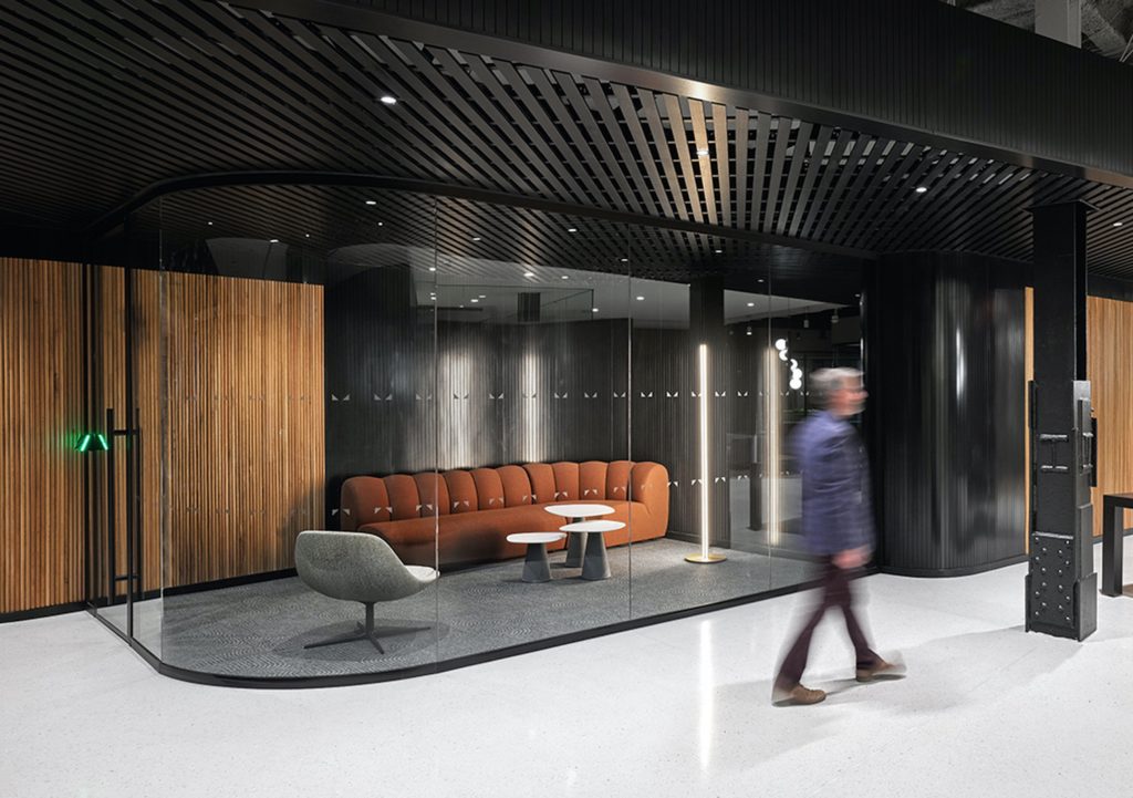 man walking in consultancy firm with Fino curved glass walls next to him