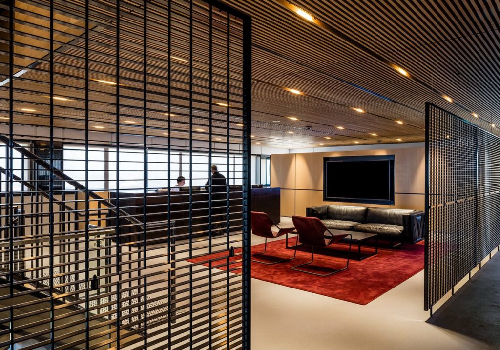 wood slat drop-in ceiling in workspace with rep carpet and comfy seating