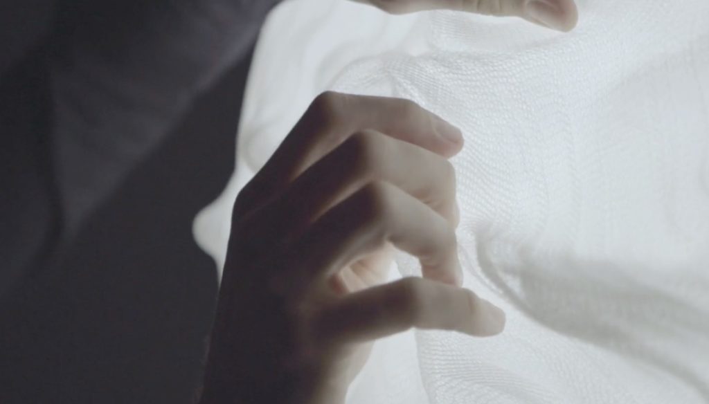 Detail of hands manipulating Nuée fabric