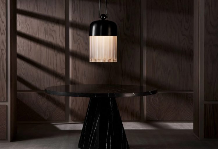 Tassel chandelier with black brass dome above black table