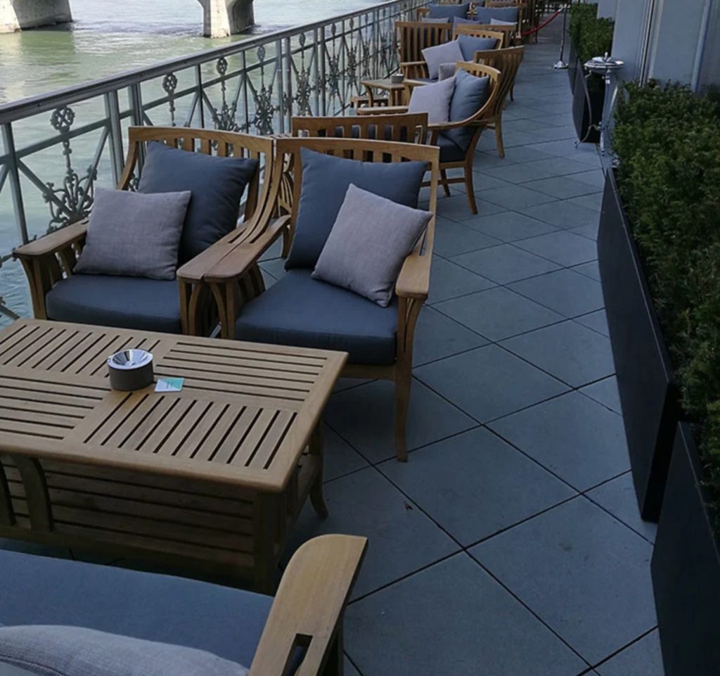 Art Deco furniture with slate-colored cushions on waterfront patio