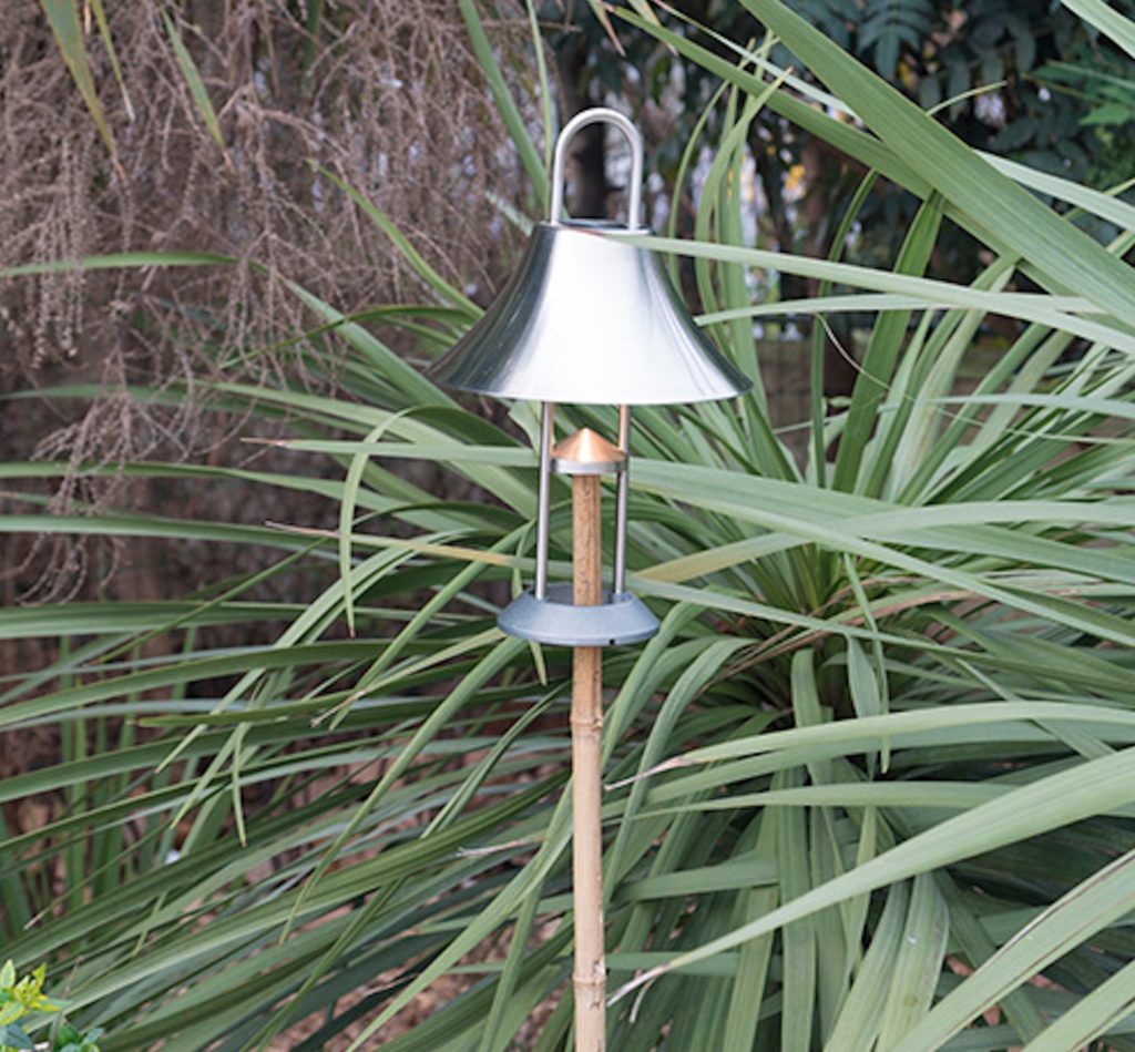 Mosqueton with silver shade supported by a branch through the bottom with jungle leaves in the background