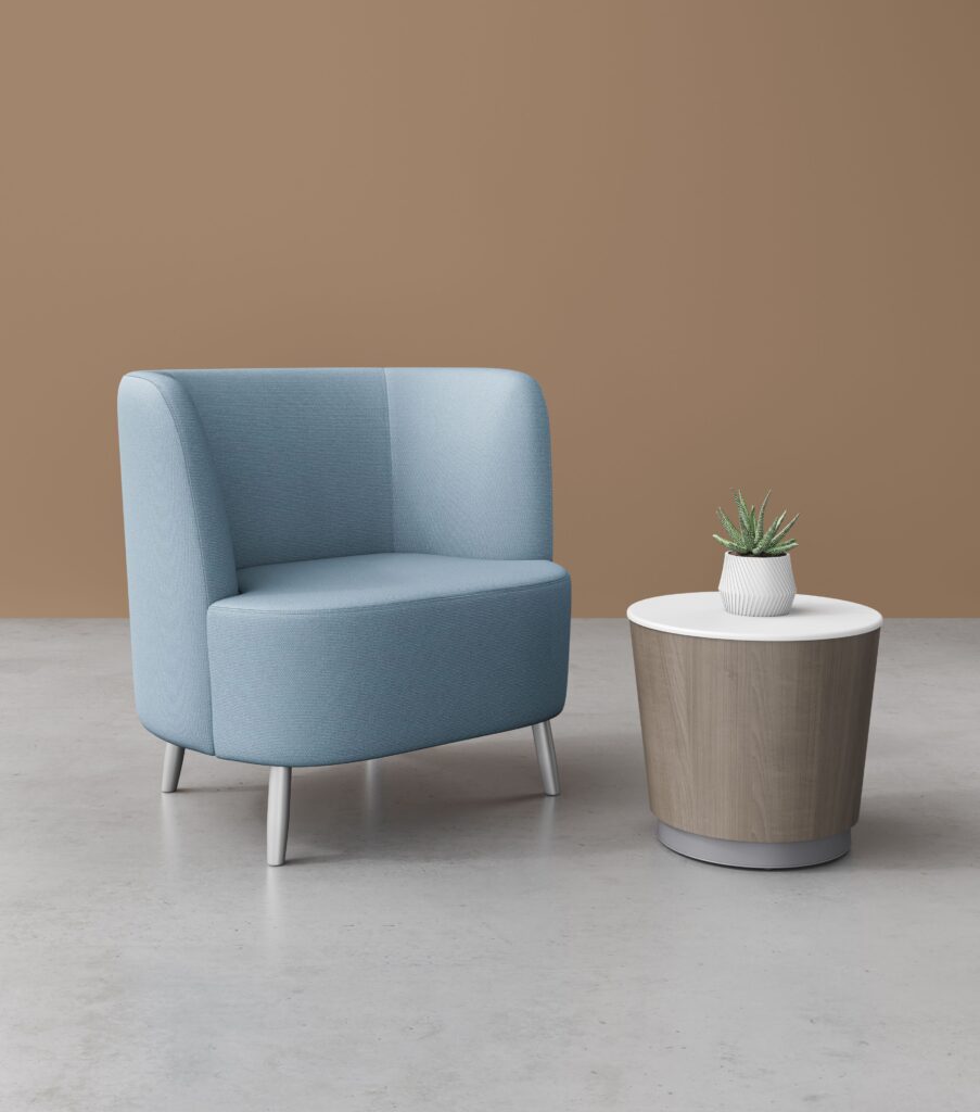 Capri table with medium brown finish and white top next to blue lounge chair 
