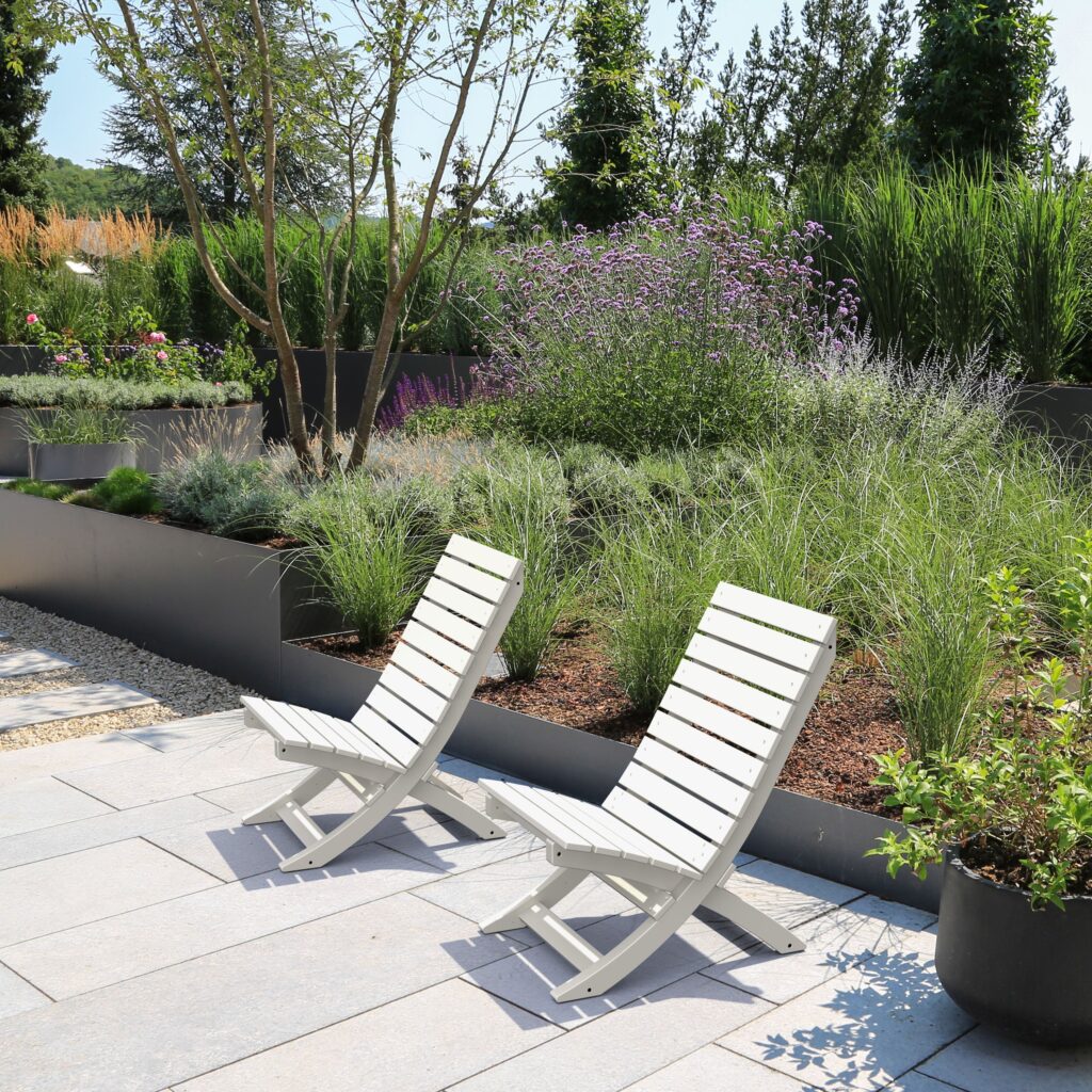 Adirondack chairs in front of nice planting area