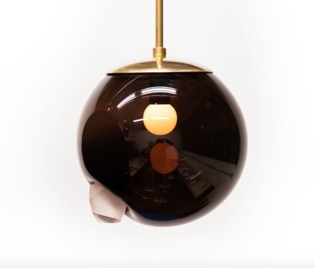 Launch Pad Dark Matter Glass Sculpture with reflected imaged of light
