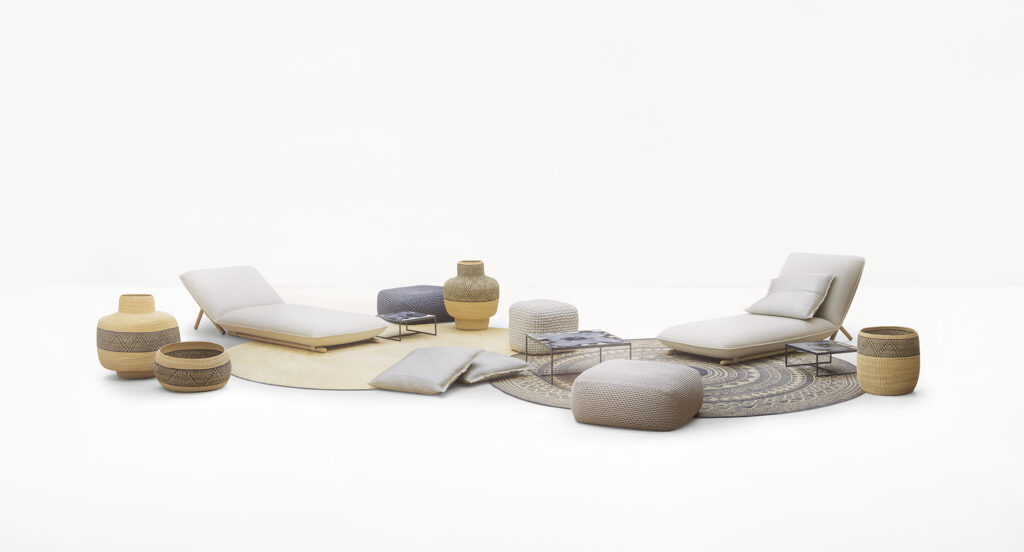 Hiro Chaise with circular carpets, ottomans, and decorative pottery