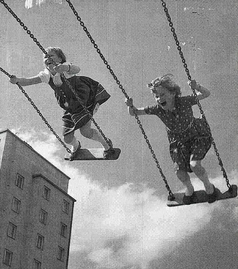 Black and white image of girls swinging