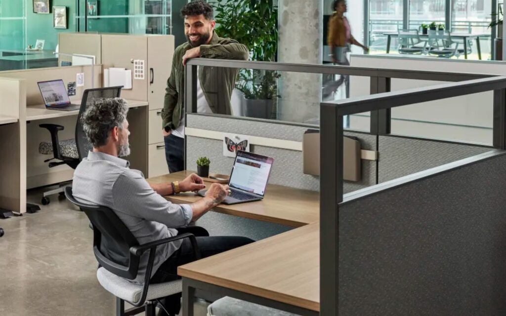 Man working while speaking to another man in Etarran workstation