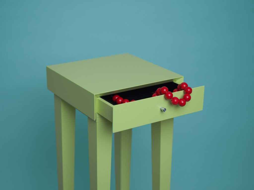 Suzanne sole dresser in green with red bead necklace