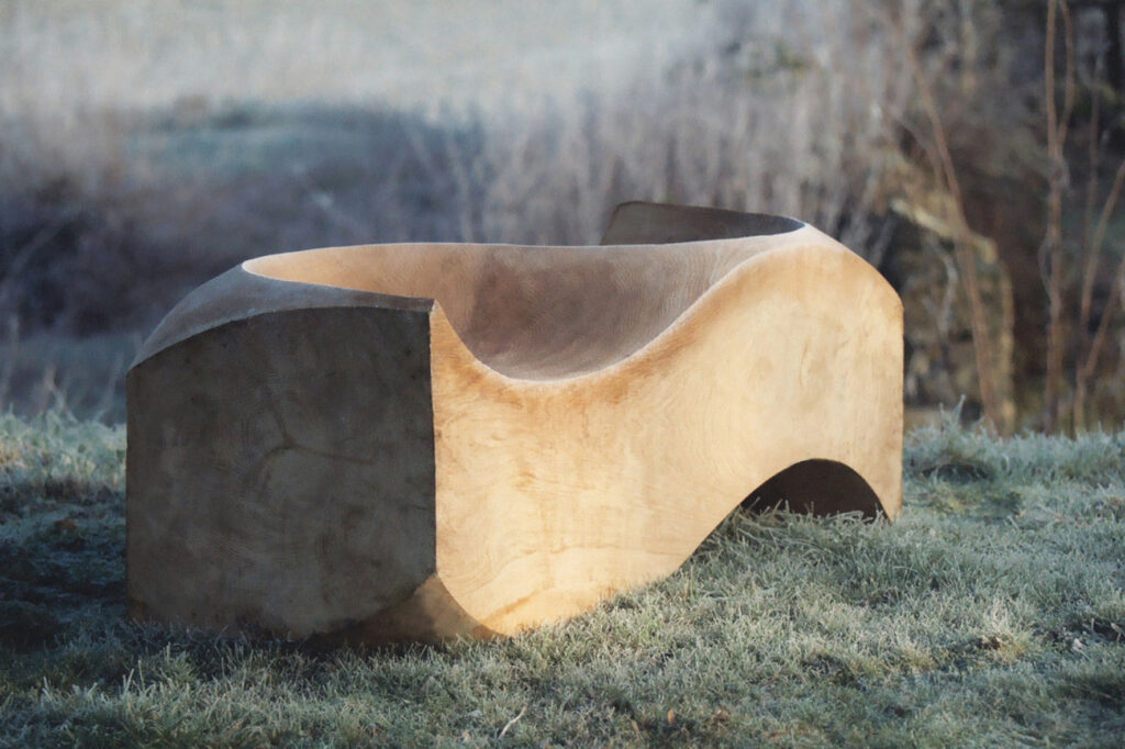 Loveseat in solid wood photographed outdoors