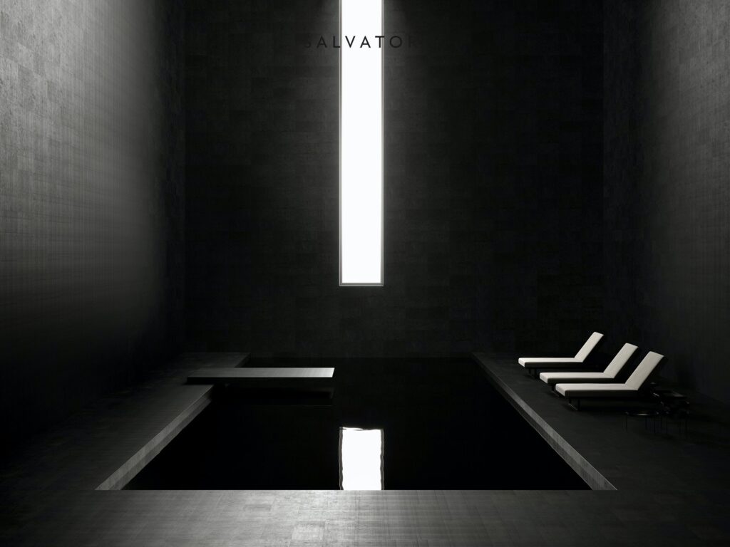 Black stone tatami surrounding small pool on floor and walls