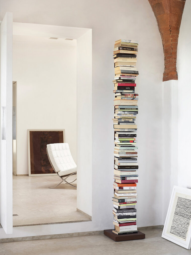 freestanding bookcase full of books with view of Barcelona Sofa in background