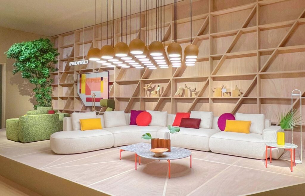 Jeff in white with colorful pillows against built-in bookshelves