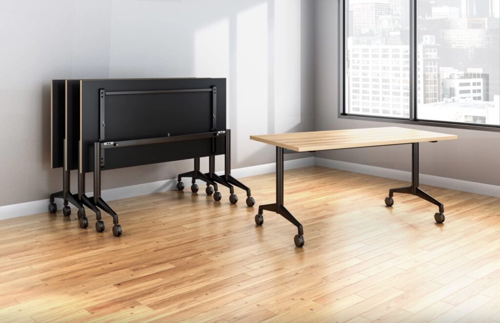 Training table with natural wood top and black base next to three nested tables