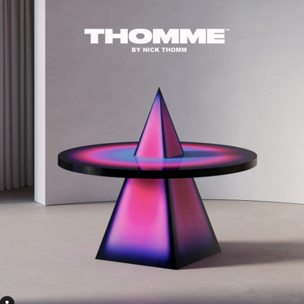 Table with pink pyramid and top punctured by tip of pyramic