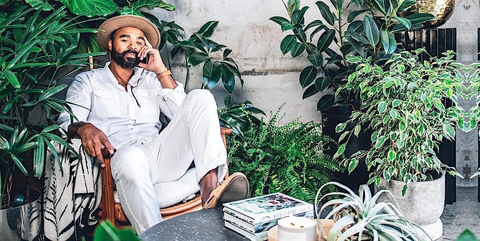 Designer Hilton Carter surrounded by plants 